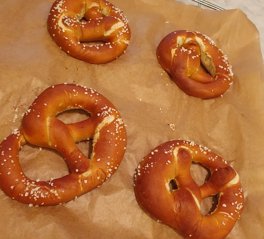 Four salted pretzels on baking paper.