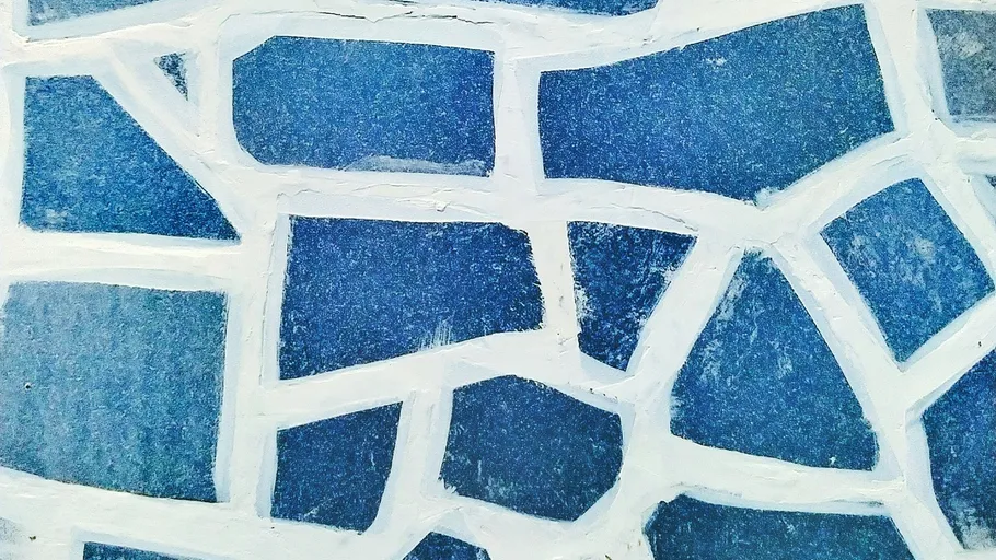 Blaue Mosaiksteine mit weißem Mörtel.