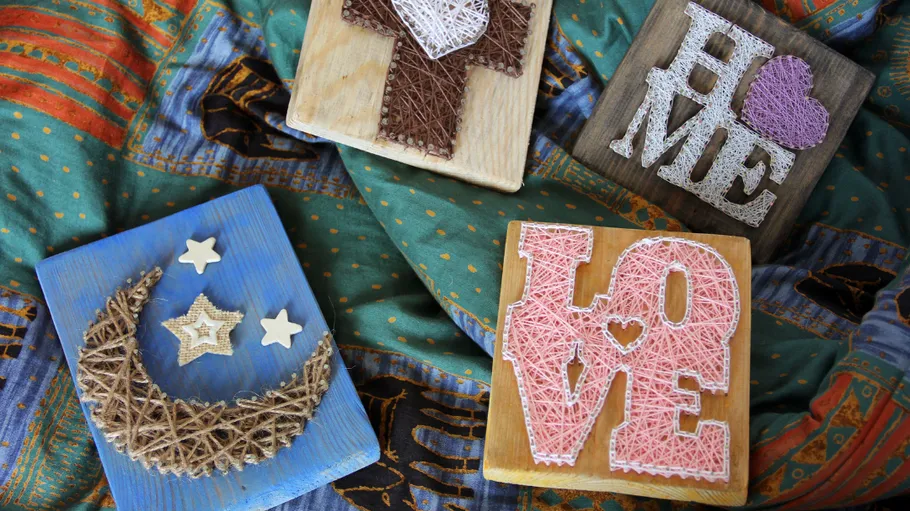 String art on wooden blocks on fabric.