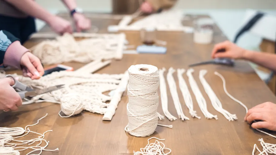 People cutting string for crafting on table.