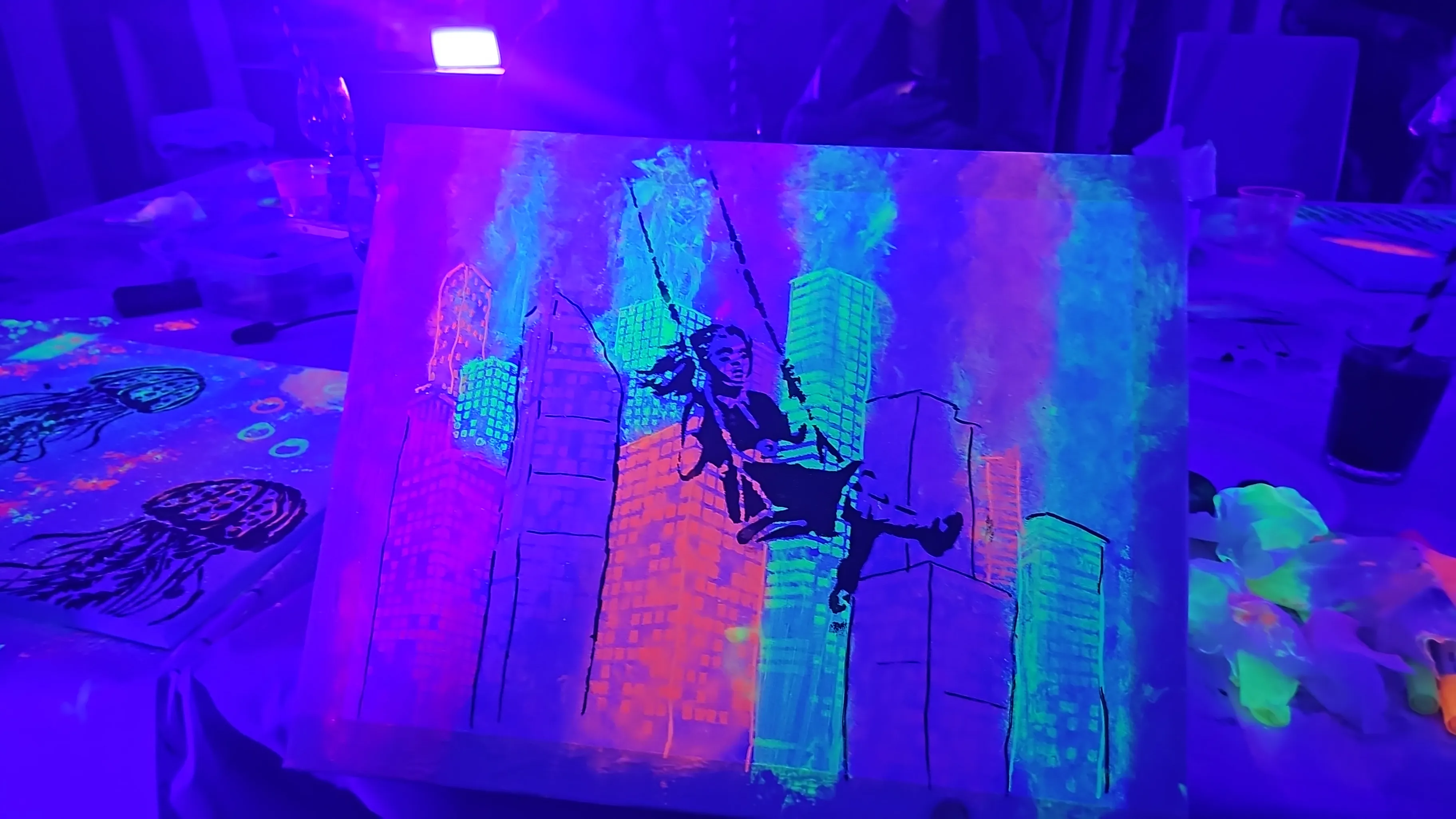 Leuchtende Stadtlandschaftsmalerei unter UV-Licht.