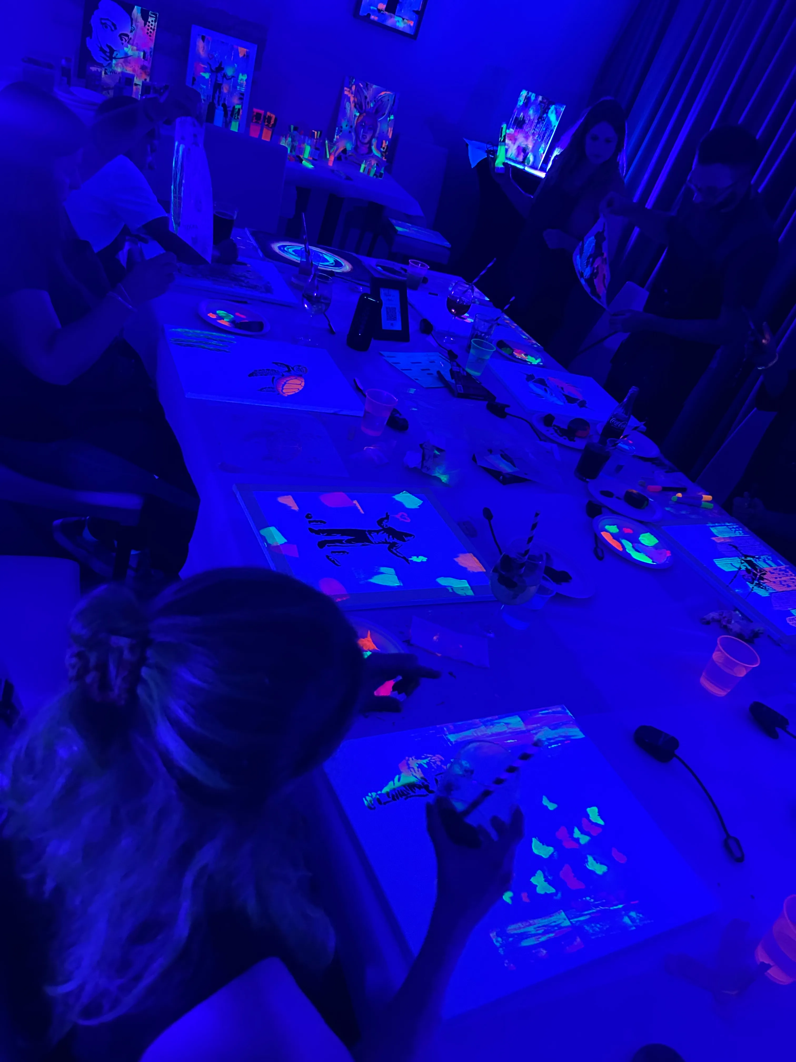 Menschen malen unter UV-Licht in einem Studio.