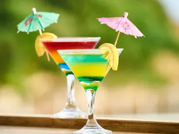 Bunte Cocktails mit Schirmchen und Zitrone im Freien.