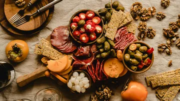 Charcuterie board with meats, cheese, and fruits.
