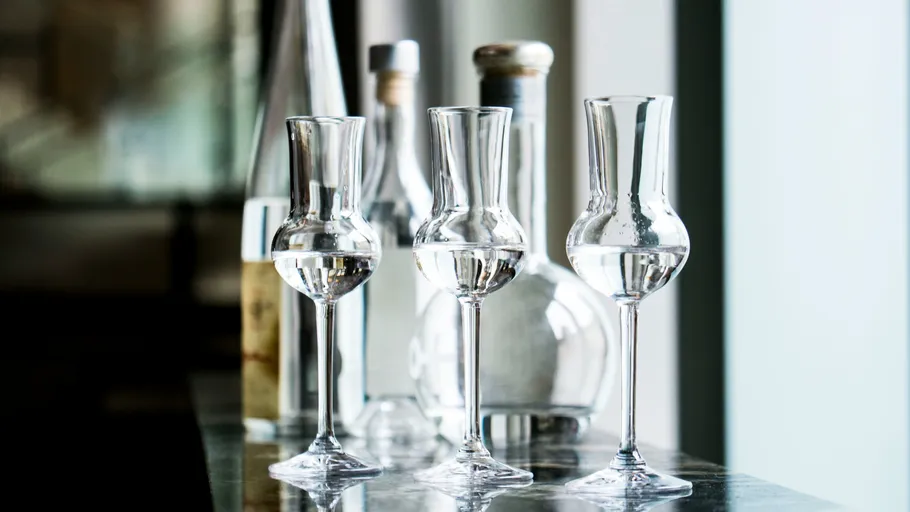 Gläser mit klarer Flüssigkeit auf einem Tisch.