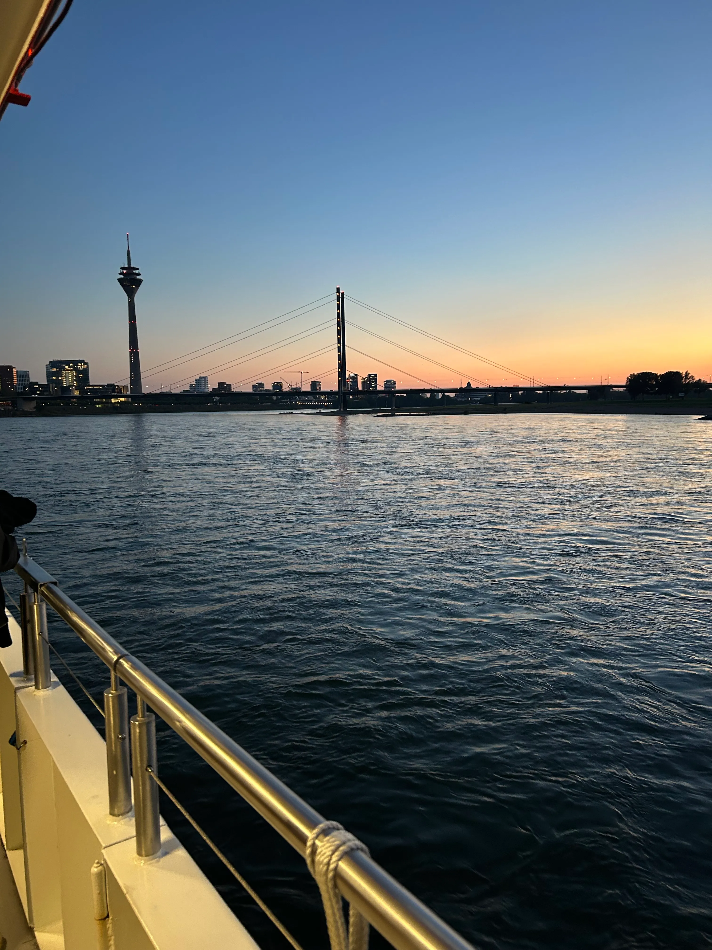 Boot auf Fluss mit Skyline und Sonnenuntergang.