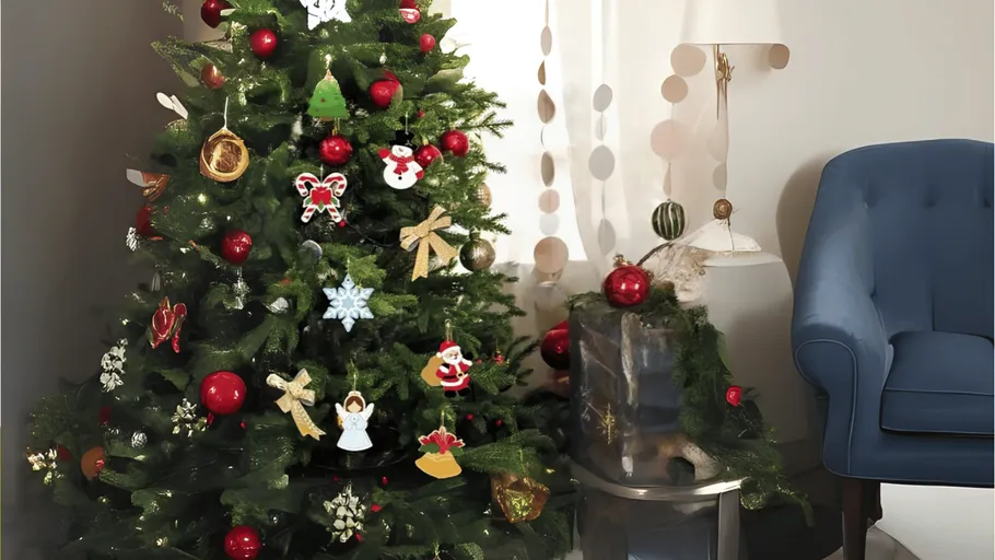 Geschmückter Weihnachtsbaum neben blauem Sessel.