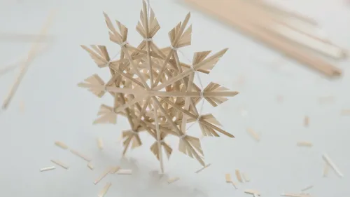 Wooden snowflake crafted on white surface.