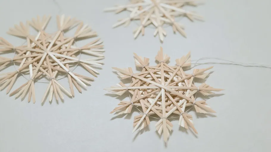Straw snowflakes on light background.