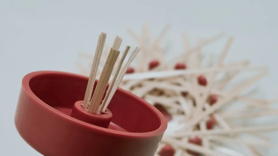 Sticks in red holder, blurred background.