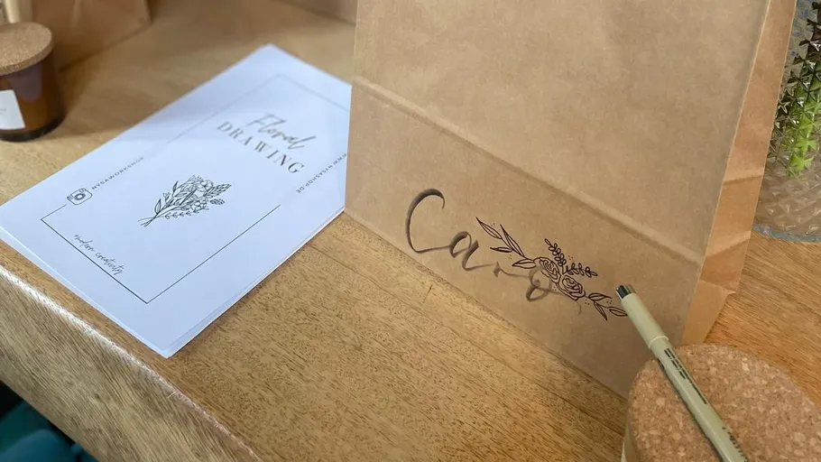Brown paper bag with pen on table.