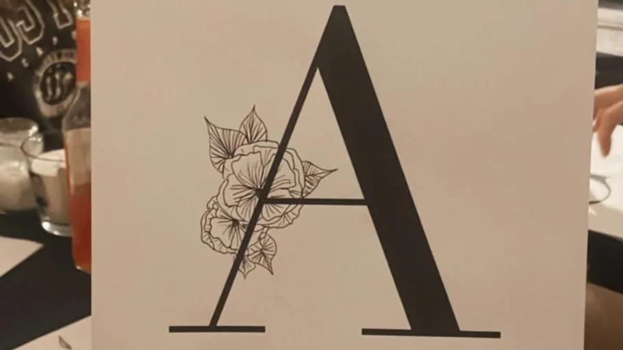 Large letter A with floral design, table setting.