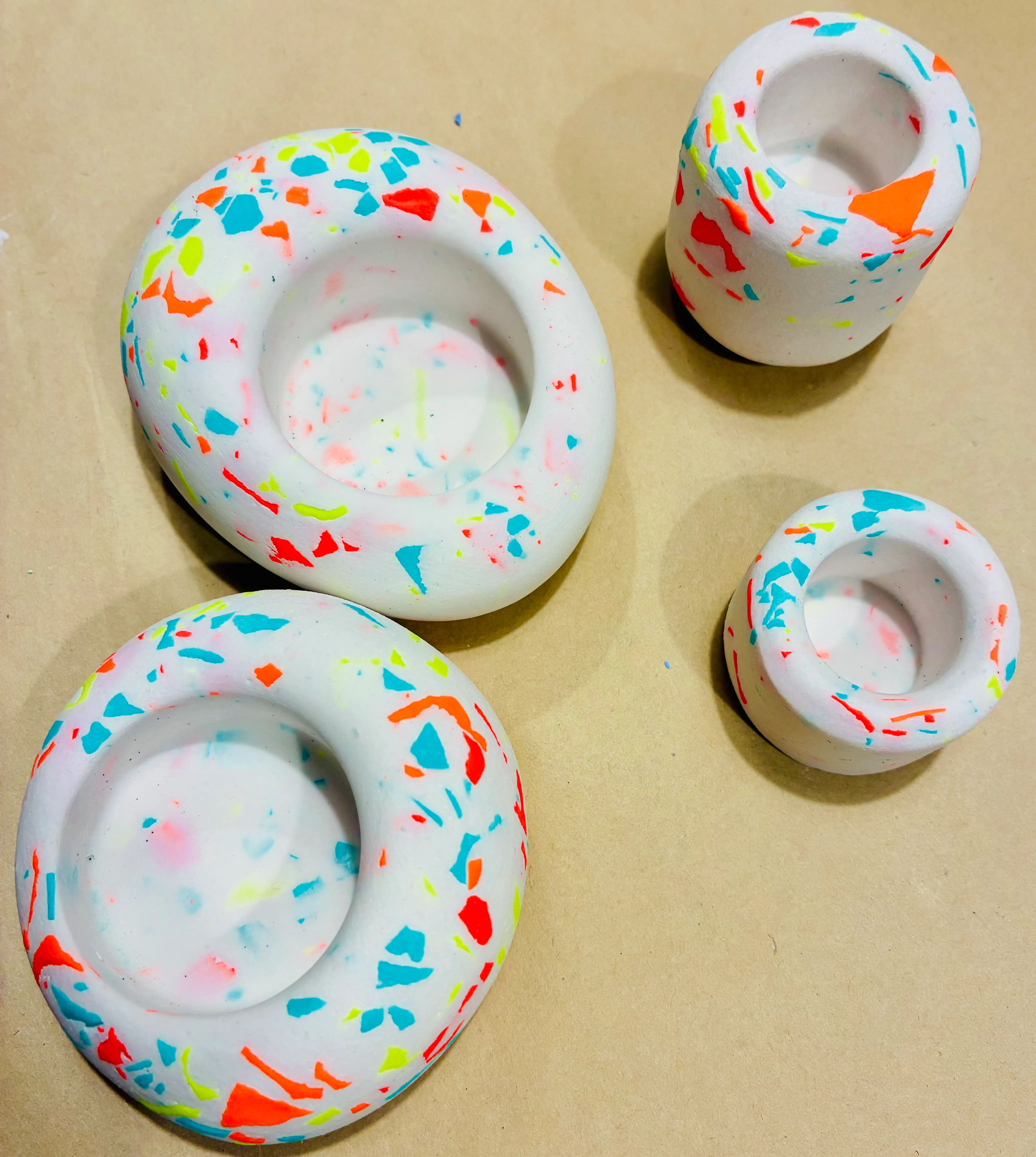 Bunte Terrazzo-Kerzenhalter auf einem Tisch.