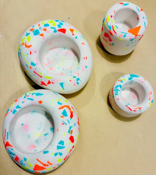 Bunte Terrazzo-Kerzenhalter auf einem Tisch.