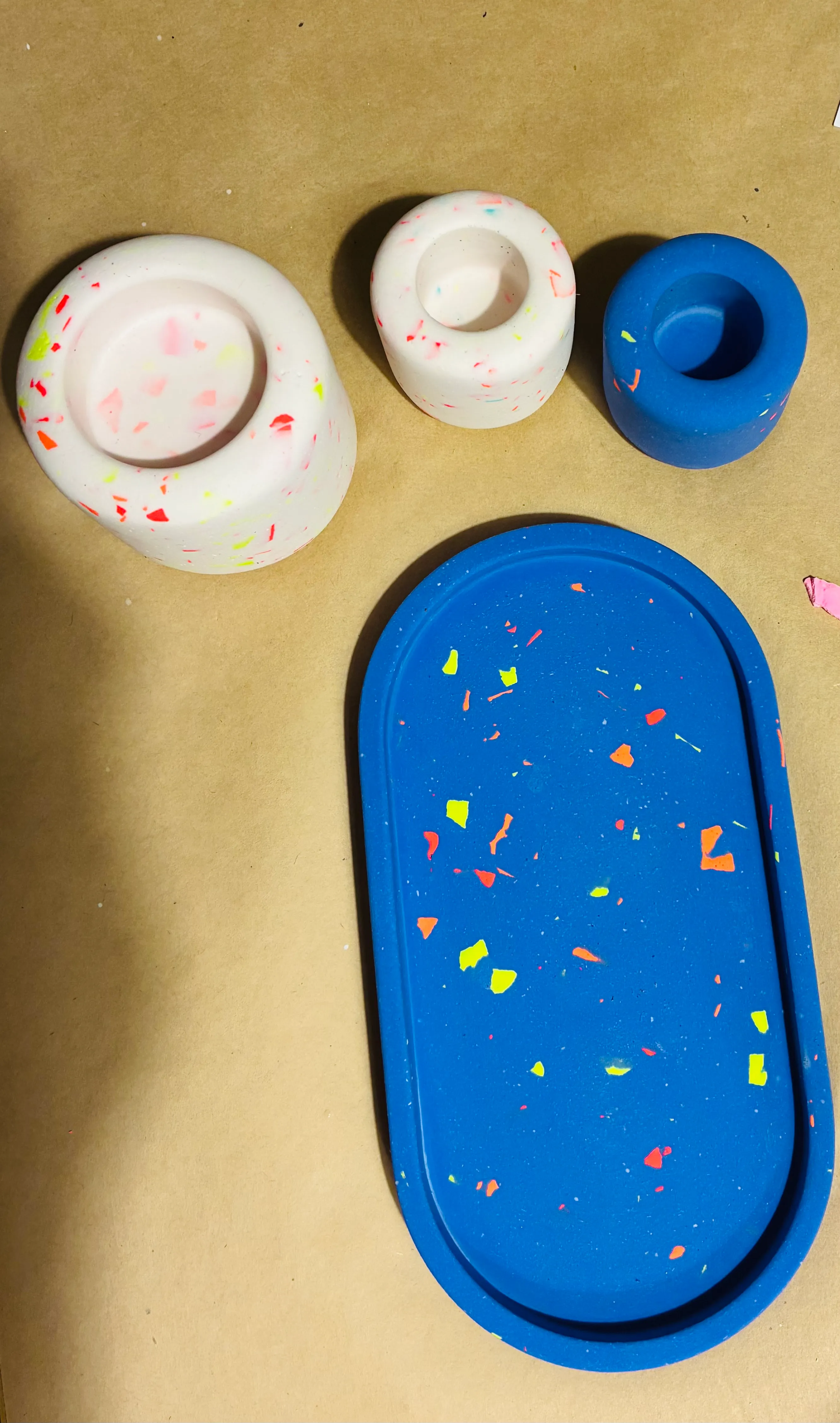 Bunte Terrazzo-Kerzenhalter und Tablett auf Tisch.