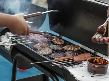 Grill with meat and sausages is prepared and grilled.