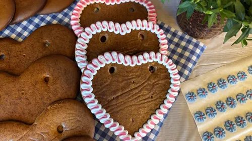 Herzförmige Kekse mit Zuckerguss auf Tisch.