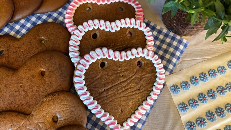 Herzförmige Kekse mit Zuckerguss auf Tisch.