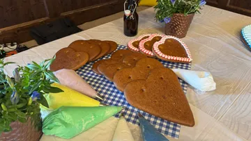 Herzförmige Kekse mit Zuckergussbeuteln auf Tisch.
