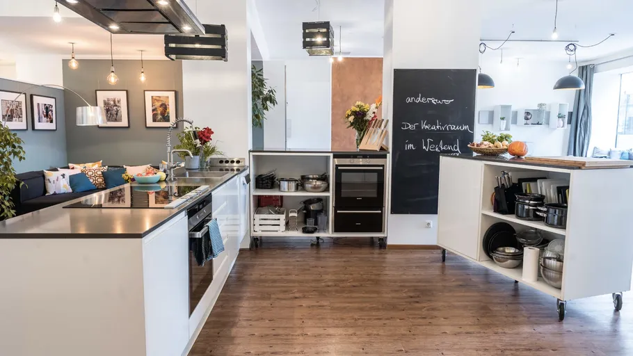 Modern kitchen with open shelves and chalkboard wall.