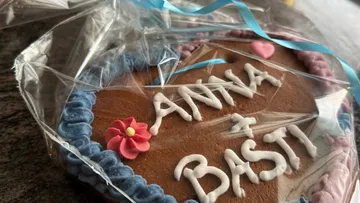 Decorated heart-shaped cookie with text under wrapping.