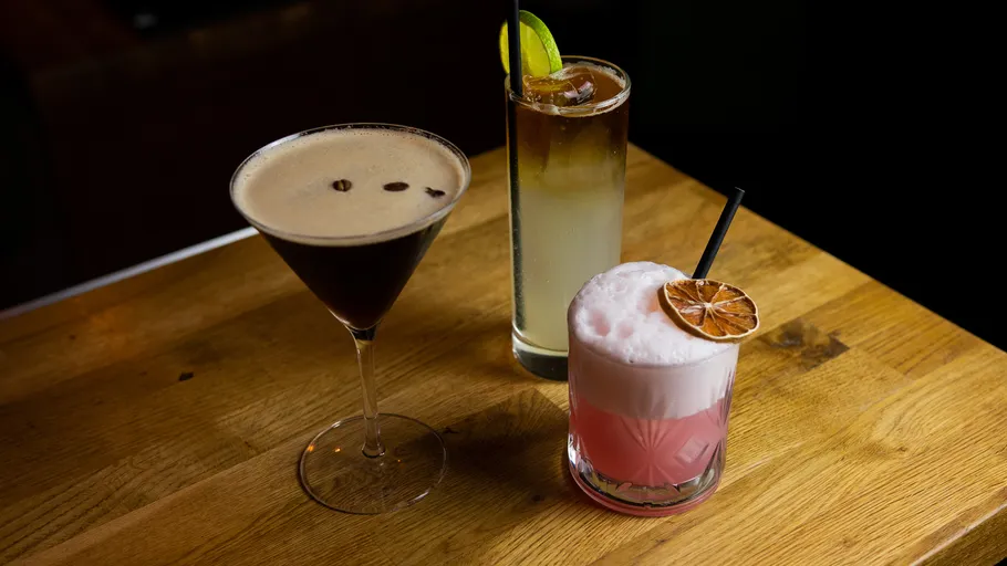 Drei Cocktails auf Holztisch.