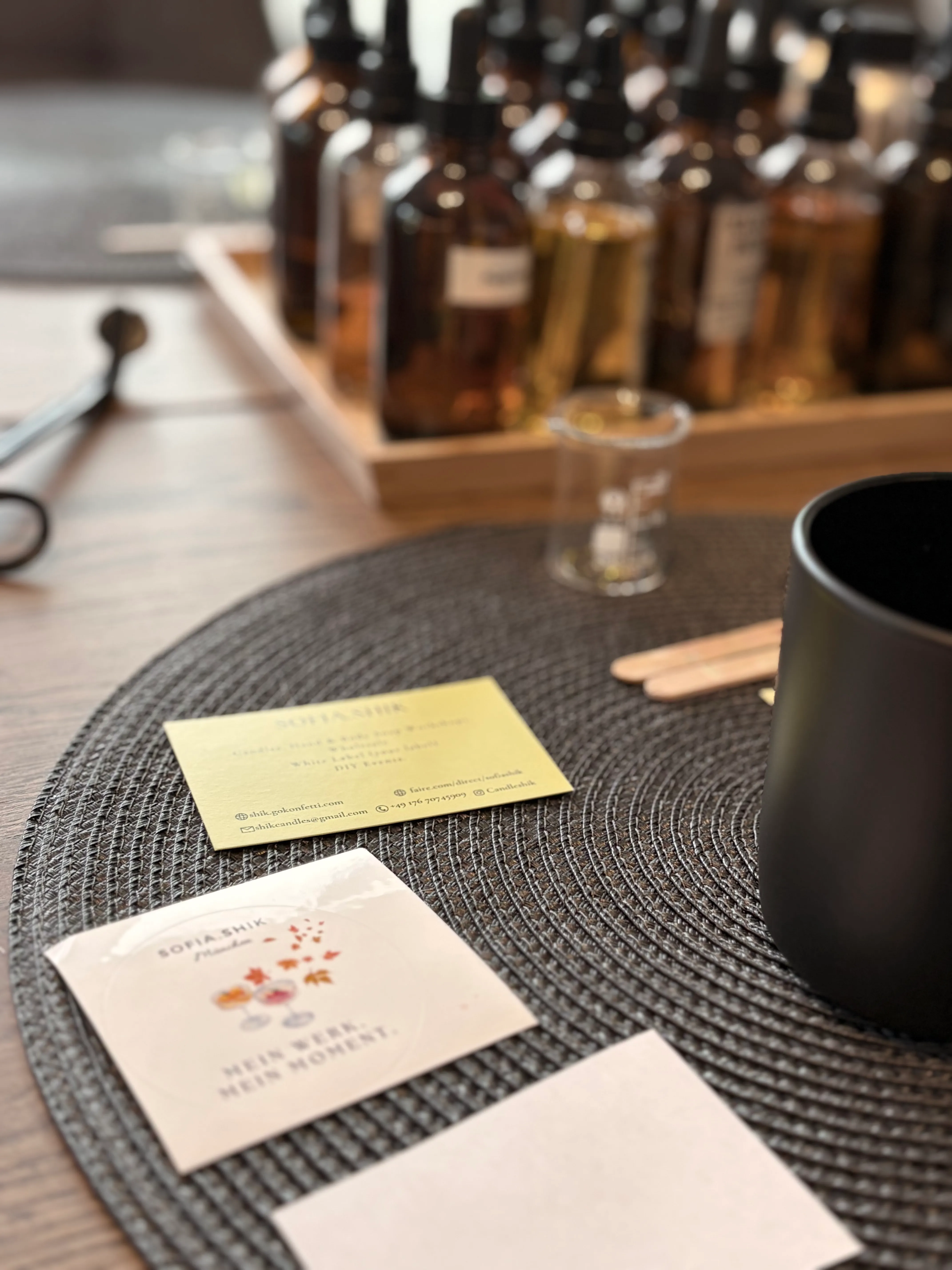 Visitenkarten auf geflochtenem Matten mit Flaschen dahinter.