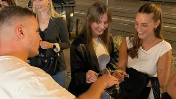 People laughing and sharing drinks on the street.