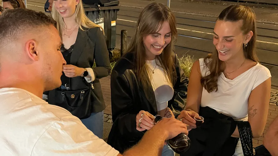 Leute lachen und teilen Getränke auf der Straße.