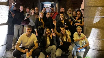 Gruppe von Personen posiert in einer Gasse.