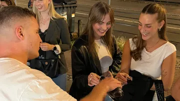Group of people smiling and toasting outdoors.