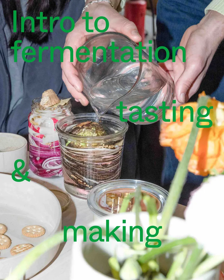 Hands pouring liquid into jars on table.