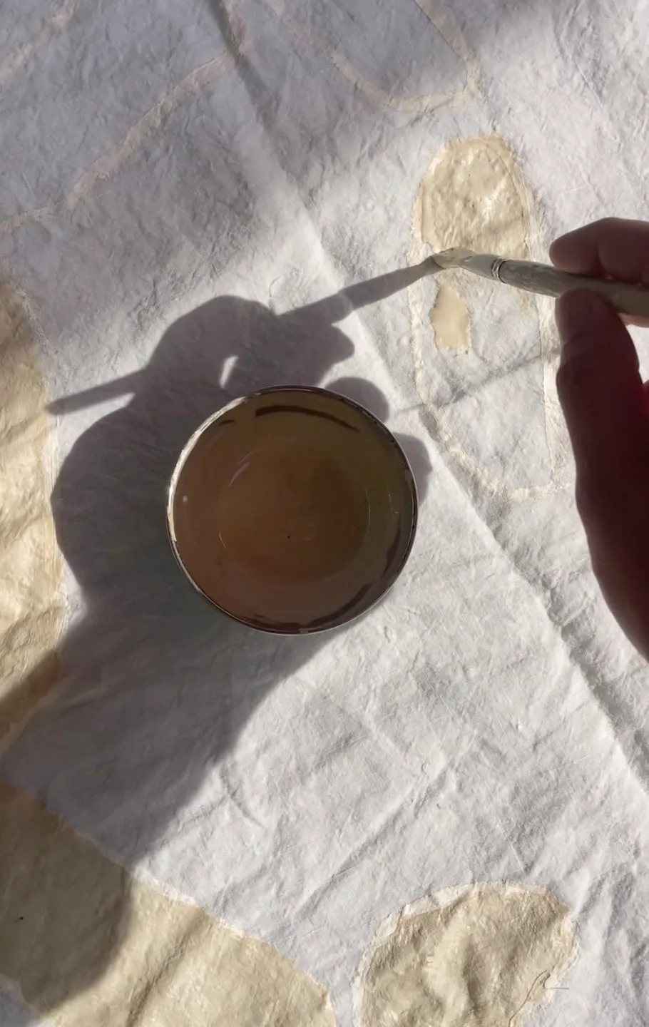 Hand painting on fabric under sunlight.