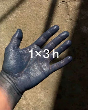 Blue-stained hand with text on palm.