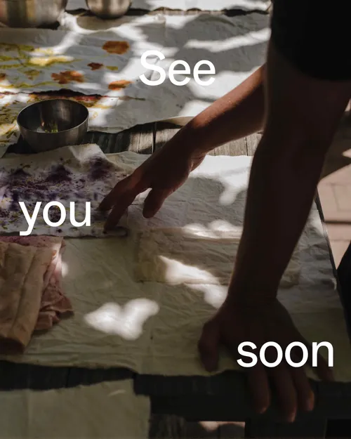 Hands arranging fabric on outdoor table.