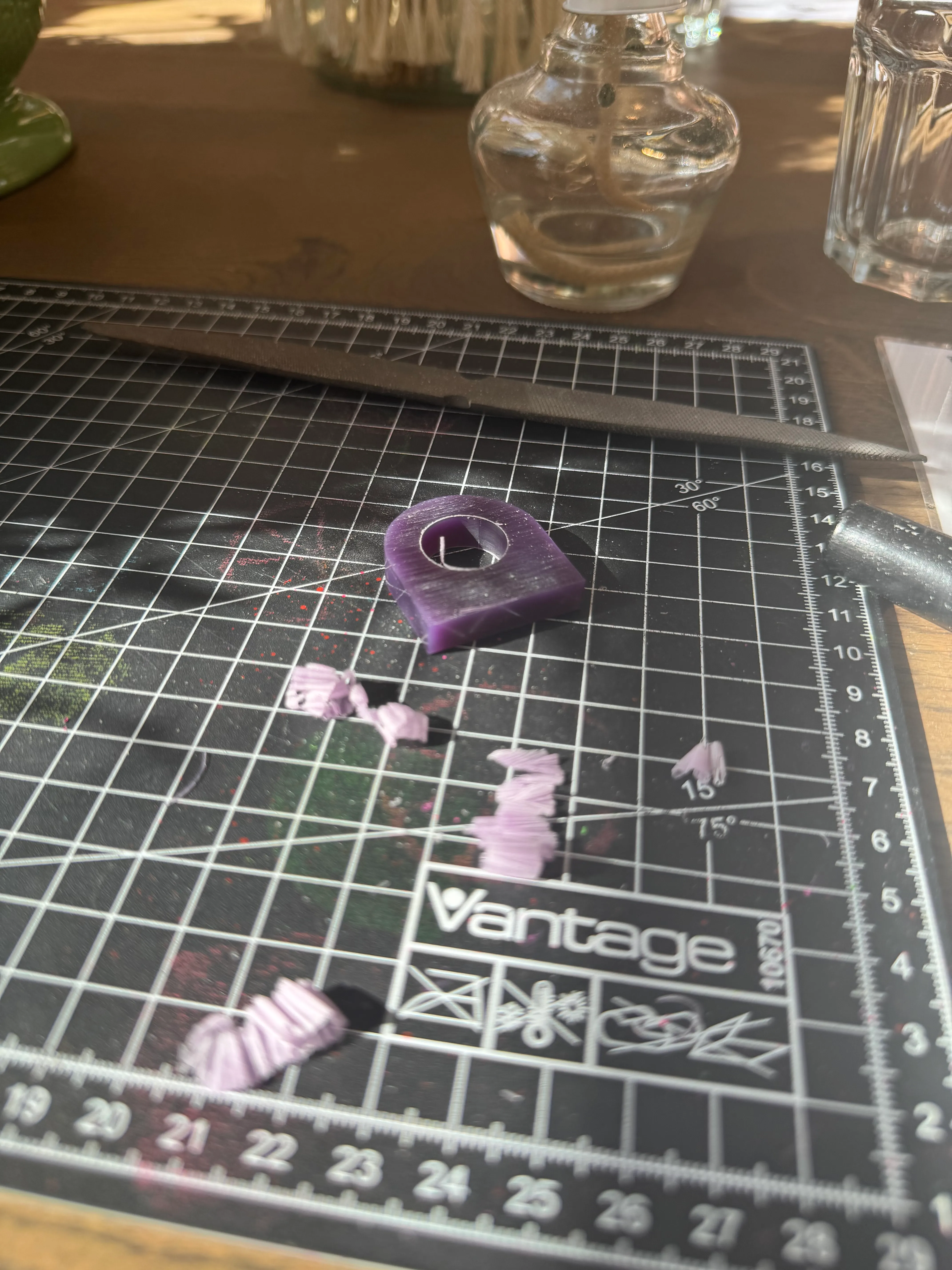 Purple wax ring on cutting mat, tools nearby.