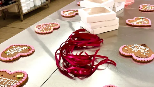 Herzförmige Kekse mit Bändern auf Tisch.