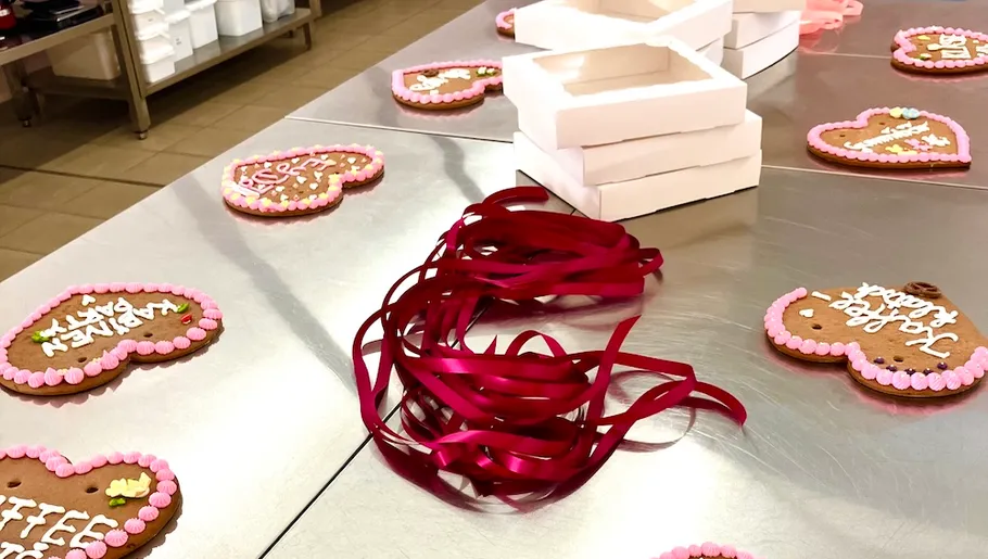 Heart-shaped cookies with ribbons on table.