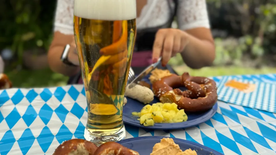 Beer and Bavarian food on blue tablecloth.