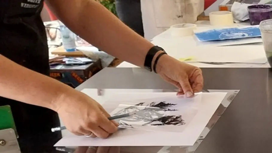Person zieht Bild auf Papier nach, drinnen.