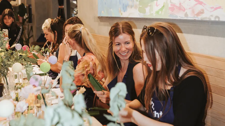 Women crafting together at a decorated table.