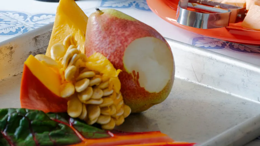 Birne und Kürbis auf Metalltablett.