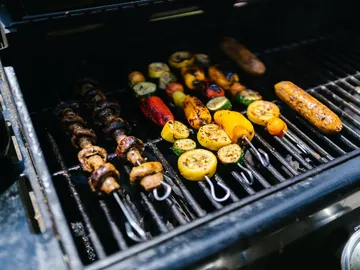Gegrilltes Gemüse und Fleisch auf einem Grillrost.