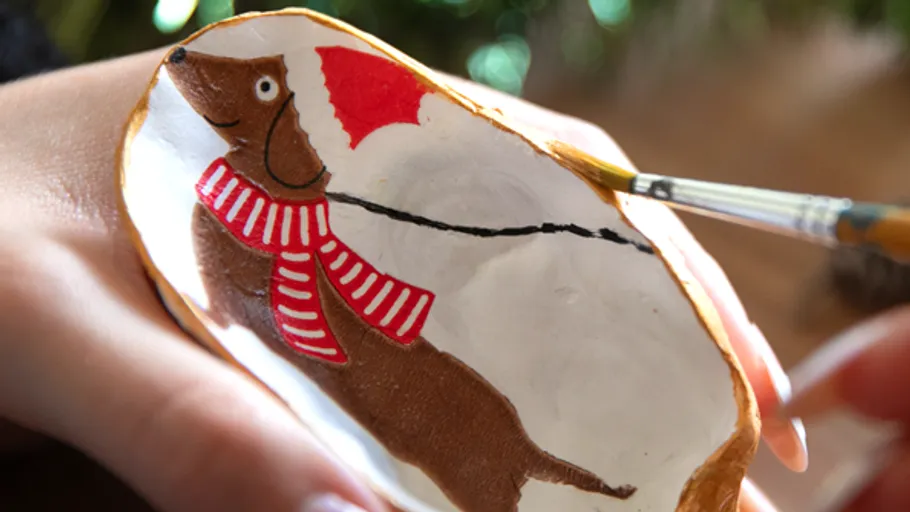 Hand painting dachshund on Christmas ornament.