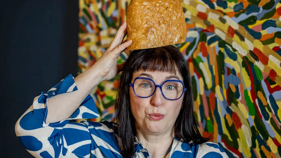 Frau mit Brot auf Kopf, bunter Hintergrund.