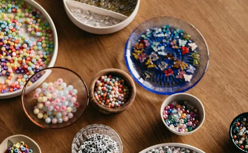 Colorful beads arranged in various bowls.