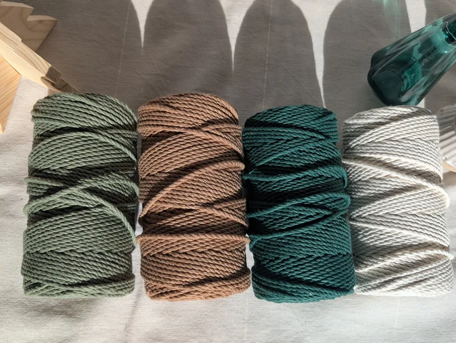 Vier bunte Garnrollen auf einem Tisch.