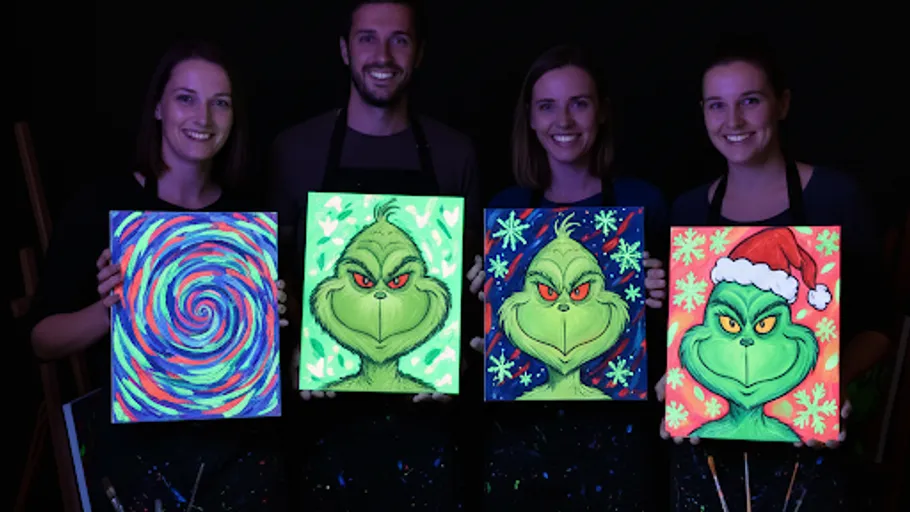 Four people holding glow-in-the-dark paintings.