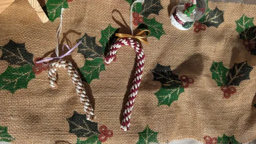 Zwei geflochtene Zuckerstangen auf Sackleinen mit Stechpalmenmuster.