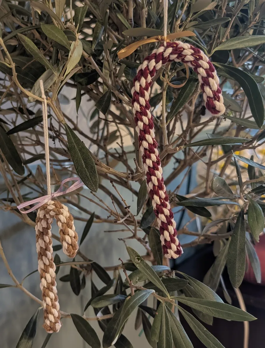 Geflochtene Zuckerstangen hängen an Zweigen.